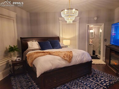 Unit 1 Bedroom featuring dark wood-type flooring, a chandelier, and ensuite bath