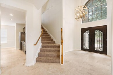 Entrance foyer with a chandelier, stairs, light t
