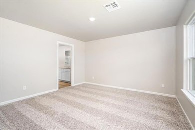 The primary bedroom is spacious with large windows