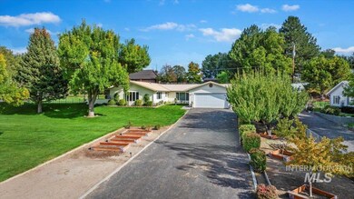 View of front facade with a garage, asphalt driveway, and solar panels