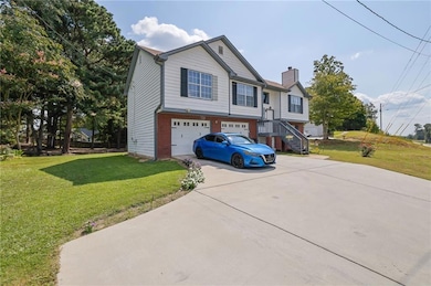 View of front of home with a front lawn, concrete driveway, an attached garage, and stairs
