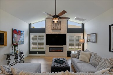 Living room with lofted ceiling, a ceiling fan, a