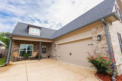 View of front of home featuring a garage and a por
