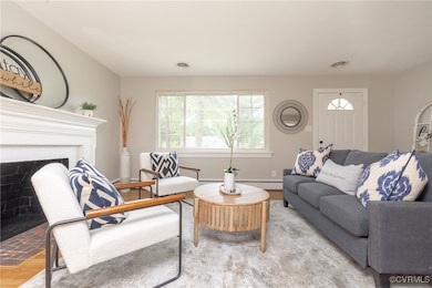 Living room featuring a brick fireplace and wood f