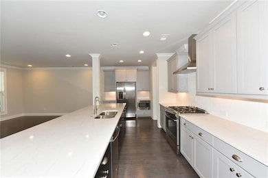 Kitchen with crown molding, light stone countertop