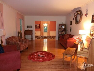 The living room has wood floors & crown molding