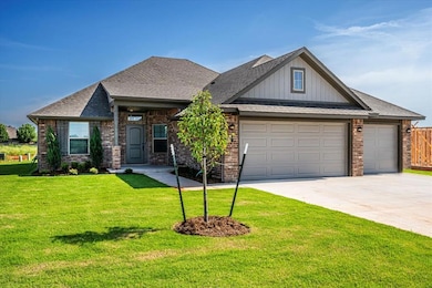 View of front of property with concrete driveway, an attached garage, brick siding, a front yard, and board and batten siding