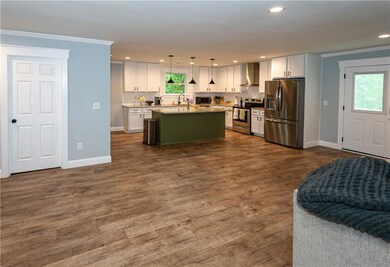 Kitchen featuring wall chimney range hood, crown m