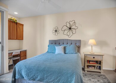 Primary bedroom with desk and cabinets