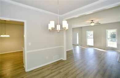 dining area featuring a chandelier, wood finished floors, a ceiling fan, and crown molding