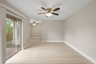 Empty room featuring ceiling fan, light wood fini