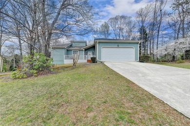 View of front of property featuring a garage, driv