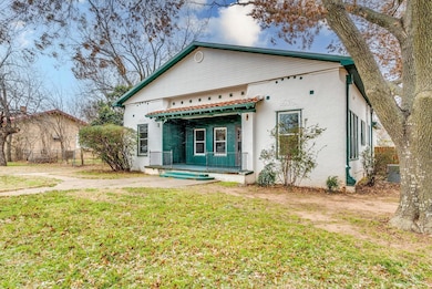 Rear view of property with fence, a lawn, and stuc