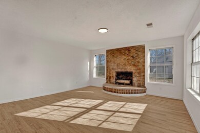 Unfurnished living room with brick wall, a firepla