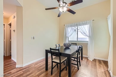 Dining space with wood finished floors, ceiling fa