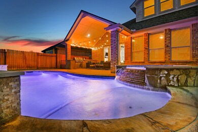 Pool features a custom rock/stone waterfall from the spa to the pool. This is an AMAZING backyard.