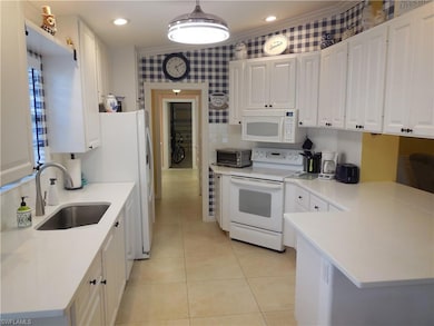 Kitchen featuring white appliances, white cabinets