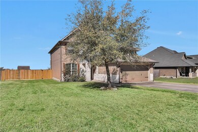 View of front of home with brick siding, fence, a