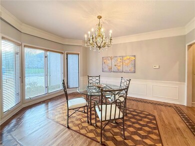 Dining area with hardwood / wood-style flooring, a notable chandelier, and ornamental molding