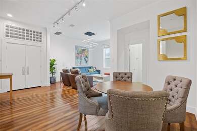 Dining room featuring wood finished floors, rail lighting, and crown molding