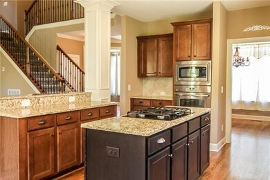 Black accented island completes this designer kitchen.  Stainless steel appliances, pantry, and open layout.