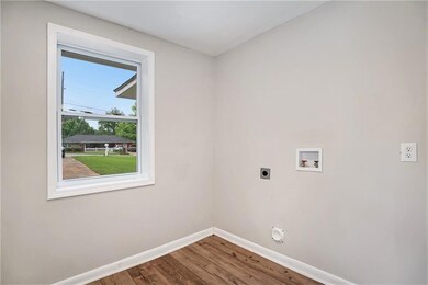 Laundry room featuring electric dryer hookup, baseboards, washer hookup, and wood finished floors