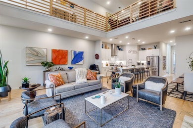 Living room featuring visible vents, light wood fi