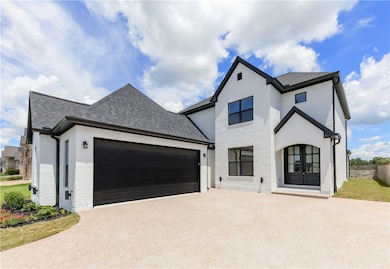 View of front of home featuring driveway, a garage