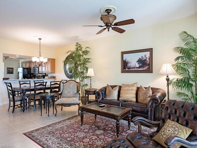 Tiled living room with ceiling fan with notable chandelier