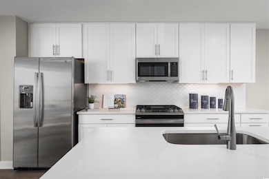 Kitchen featuring tasteful backsplash, white cabin