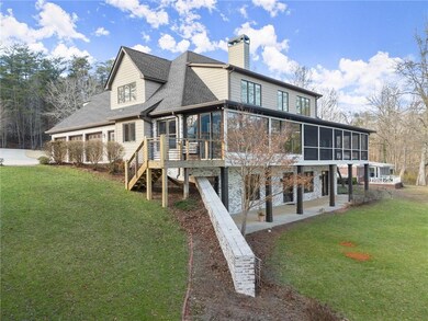 Rear view of house featuring a sunroom, a chimney, a lawn, a wooden deck, and stairs