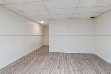 Unfurnished room featuring wood finished floors and a paneled ceiling
