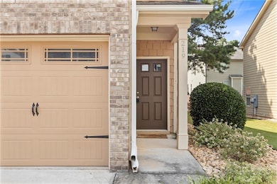 Entrance to property featuring stone siding and a garage