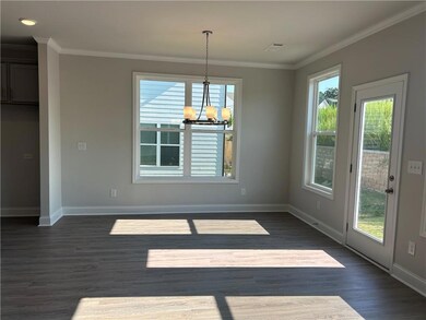 Unfurnished dining area featuring a chandelier, dark wood-type flooring, and crown molding