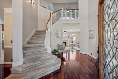 The entry foyer boasts soaring ceilings, offering sightlines and a smooth transition throughout the home's designated spaces.
