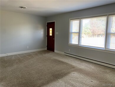Unfurnished room featuring light carpet and baseboard heating