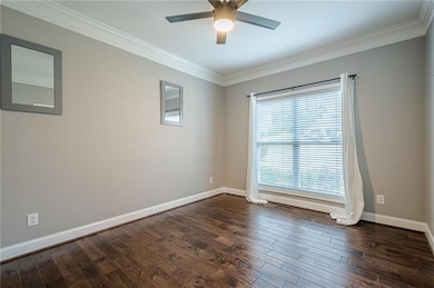Unfurnished room featuring crown molding, ceiling fan, and dark wood-style floors