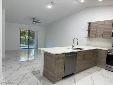 Kitchen with lofted ceiling, sink, ceiling fan, stainless steel appliances, and kitchen peninsula
