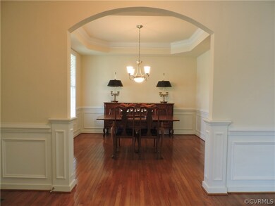 Formal dining room has tray ceiling with crown tri