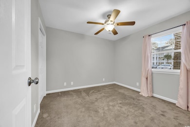 Empty room with baseboards, ceiling fan, and carpe