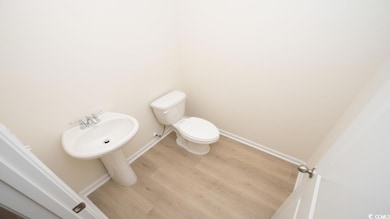 Bathroom with baseboards, wood finished floors, an
