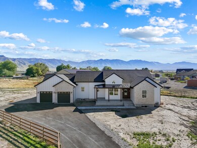 Modern farmhouse with asphalt driveway, a mountain view, a porch, and a standing seam roof