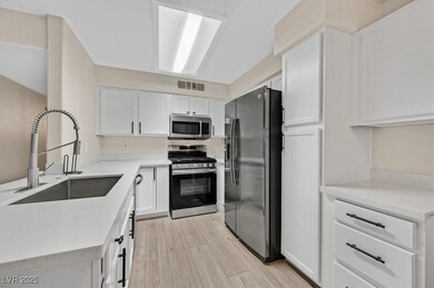 Kitchen with stainless steel appliances, white cab