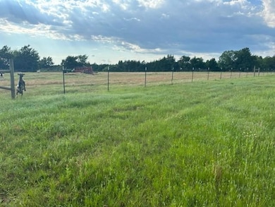 View of yard with fence and a rural view