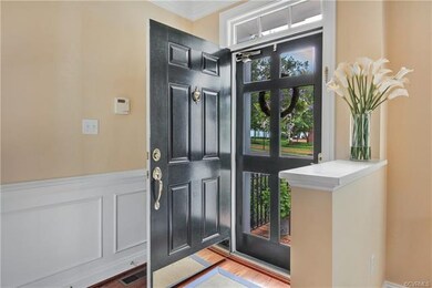 Open foyer with wood-trimmed storm door and wainsc