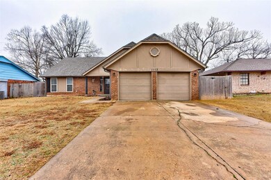 Ranch-style house featuring a garage and a front y