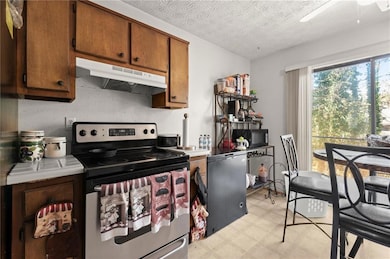 Kitchen featuring brown cabinetry, electric stove,