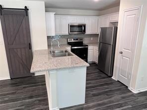 Kitchen with dark wood finished floors, appliances