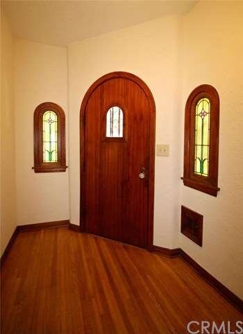 Entry door flanked by stained glass windows and ma