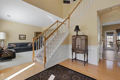 Entry with hardwood flooring and plenty of light looking into living room